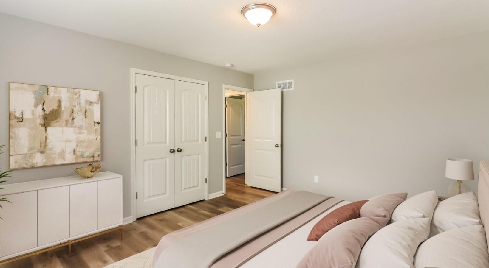 Sleep in style a room with white walls and a wood floor with a white couch and a painting on the wall